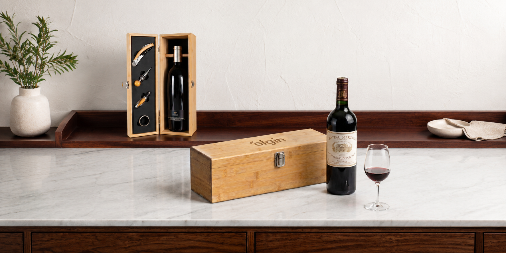 Case de vinho em bambu com garrafa e taça sobre bancada de mármore